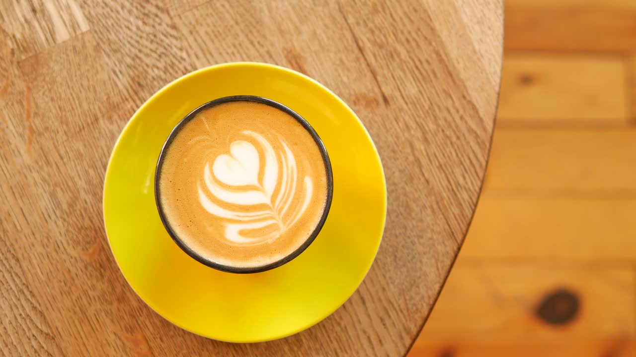 Latte with heart latte art on a wooden table