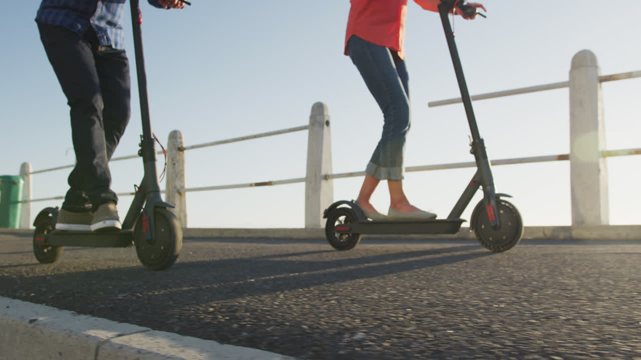 Plaj kenarında elektrikli scooter kullanan yaşlı çift