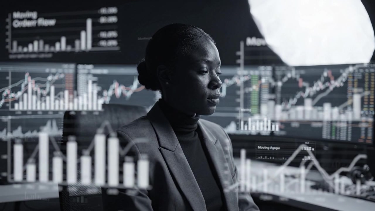 Fokuseret professionel analyserer finansielle data blandt flere aktiemonitorer i et dæmpet belyst handelsmiljø.