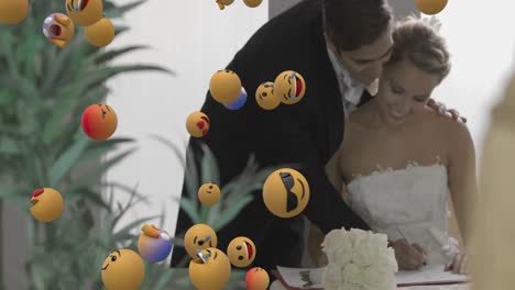 animation of emoji icons over happy caucasian married couple signing document