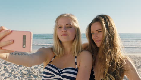 amigas tomando fotos selfie usando teléfonos inteligentes en la playa divirtiéndose compartiendo vacaciones de verano disfrutando del verano junto al mar