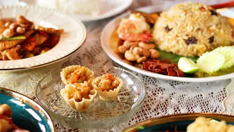 hand serving thai tartlets at a dining table