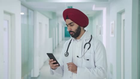 serious sikh indian doctor scrolling phone