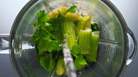 fresh liquid pouring blender with vegetables for smoothie top view close up