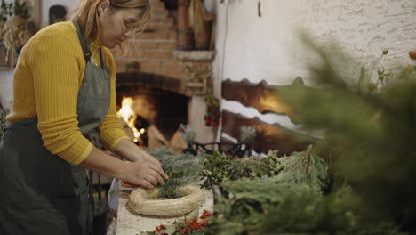 mujer haciendo una corona de navidad
