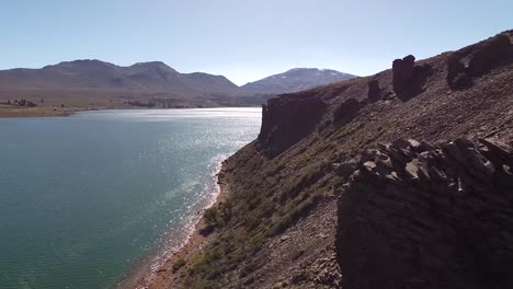 Aerial-view-over-the-lake-in-mountains,-untouched-nature-during-sunshine-day-and-clear-weather,-captured-at-Patagonia,-Argentina,-South-America