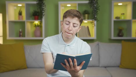 Young-man-at-home-taking-notes,-planning-and-analysis-looking-at-camera.