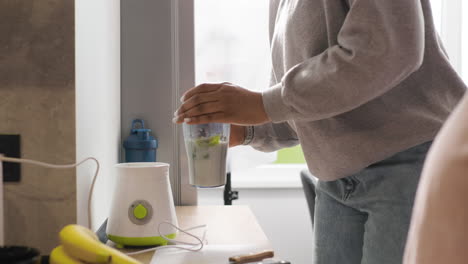 women preparing smoothie