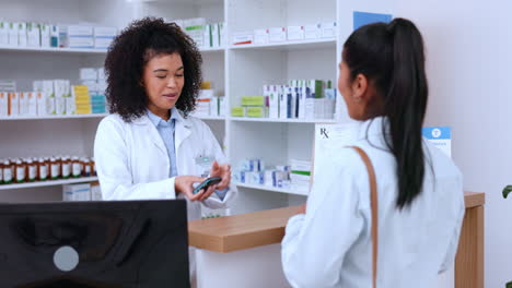 Female-pharmacist-helping-a-customer-pay