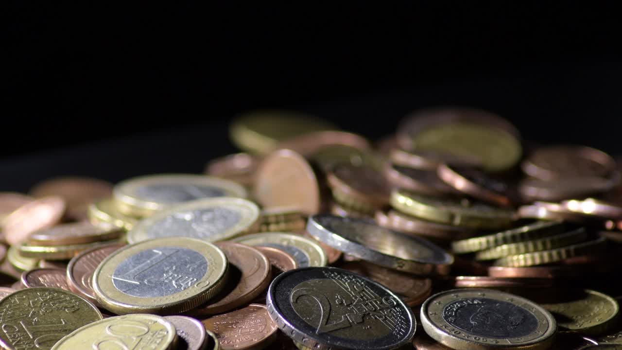 monedas usadas de dinero en euros en una montaña que se convierte en fondo negro