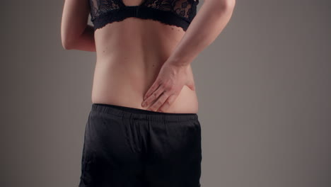 Woman Massaging Spine Due To Chronic Pain