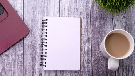 espacio de trabajo con cuaderno, portátil, café y bolígrafo