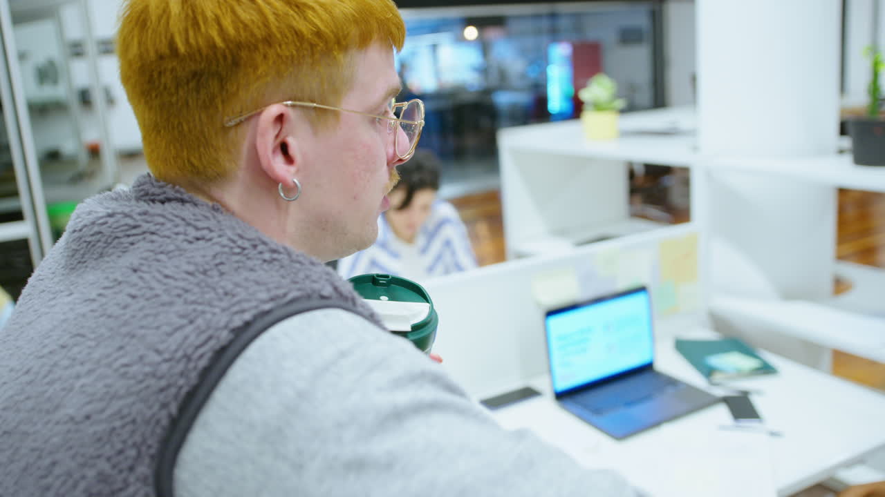 Young Black Businesswoman Talking Over Office Cubicle Wall with Colleague