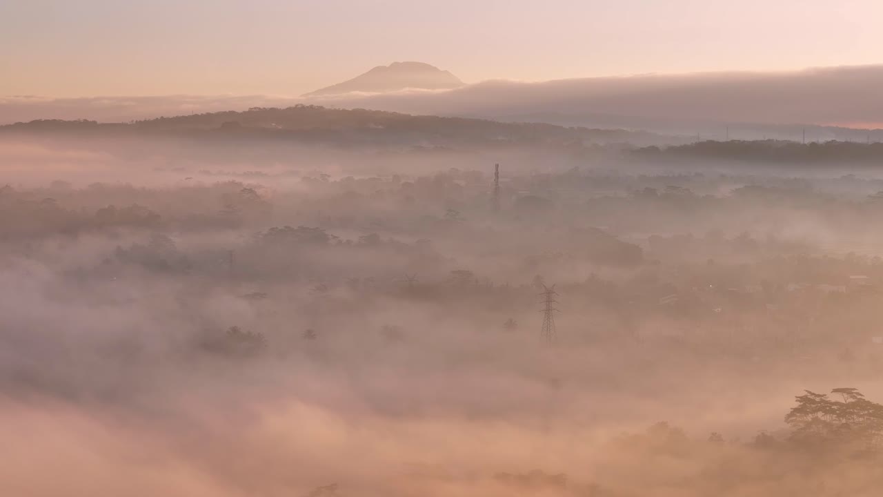 A misty morning with the pink light of a sunrise in the countryside of Indonesia,
