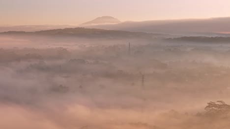 a misty morning with the pink light of a sunrise in the countryside of indonesia,