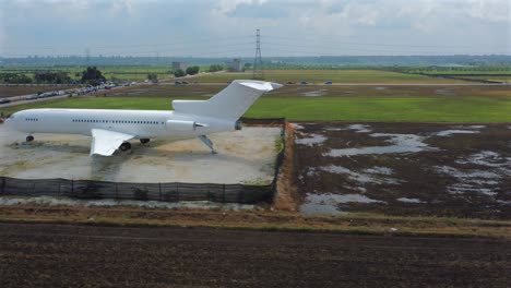 Side-slide-shot-of-an-airplane-in-the-middle-of-lush-green-paddy-fields