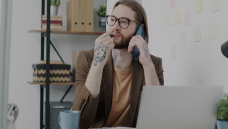 Un hombre de negocios hablando por teléfono en la oficina.