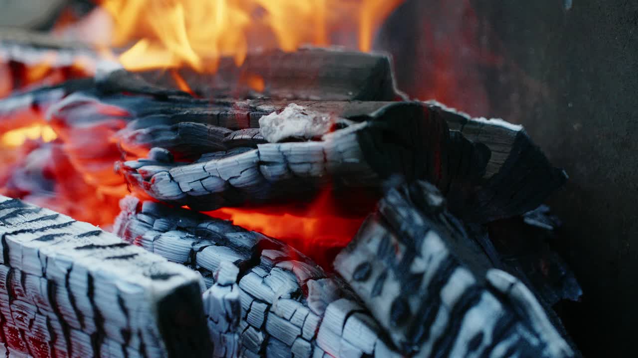 Burning log of wood close-up as abstract background. The hot embers of burning wood log fire