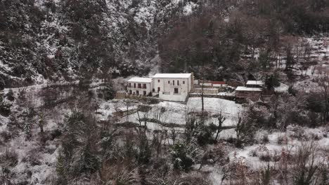 Aéreo---Pueblo-De-Virpazar-En-Invierno-Nevado,-Montañas,-Bar,-Montenegro,-Reversa