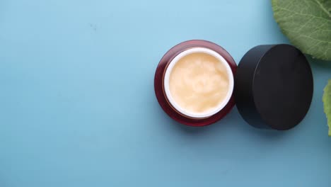 luxury face cream in a decorative jar with green leaves