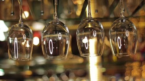 empty wine glasses hanging from the ceiling of a bar, ambience establisher