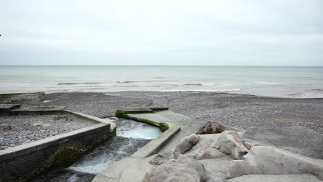 smallest french river flows into the sea on a cloudy day in normandy