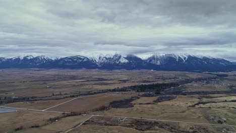 aerial shot over rural montana pushing towards mission range in distance, 4k