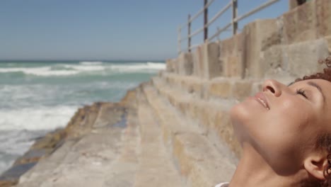 Woman-relaxing-at-beach-on-a-sunny-day-4k