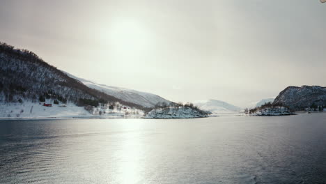 wide static shot of boat cruise sailing along the arctic fjords in norway