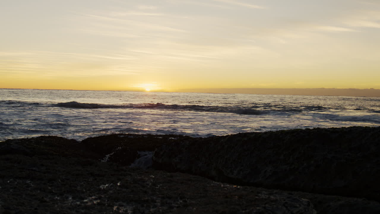 Golden hour glow across serene empty ocean water, natural background of beautiful summer tropical vibes
