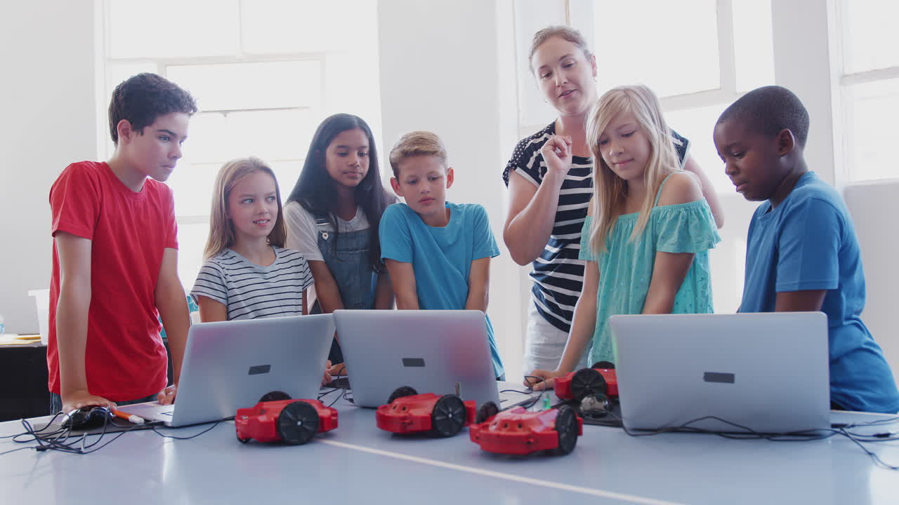 Excited Students Watching Robot Vehicle Move After Coding Lesson In Computer Programing Class