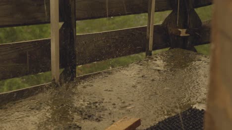 Regentropfen-Auf-Dem-Boden-Und-Tropfendes-Wasser-Vom-Zaun-Bei-Gewitter,-Statische-Aufladung