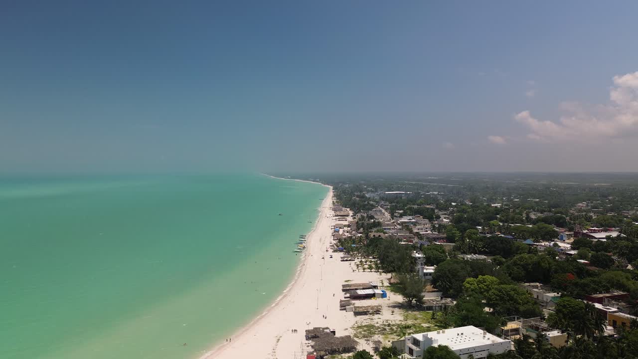 órbita aérea de una impresionante costa tropical con mares turquesa y un telón de fondo de densos bosques verdes