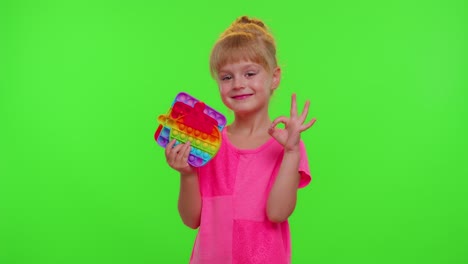 Child-girl-holding-many-colorful-squishy-silicone-bubbles-pop-it-popular-sensory-toys,-thumb-up