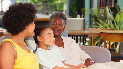 Weibliche-Familie-Mit-Mehreren-Generationen-Entspannt-Zusammen-Auf-Dem-Sofa-Zu-Hause-Sitzen