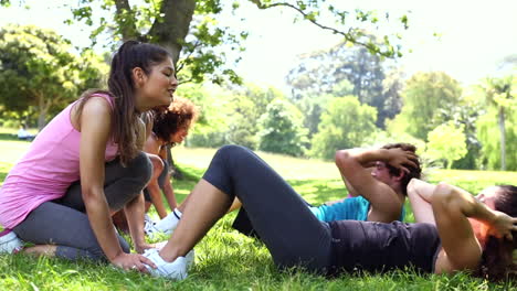 clase de fitness haciendo abdominales en el parque
