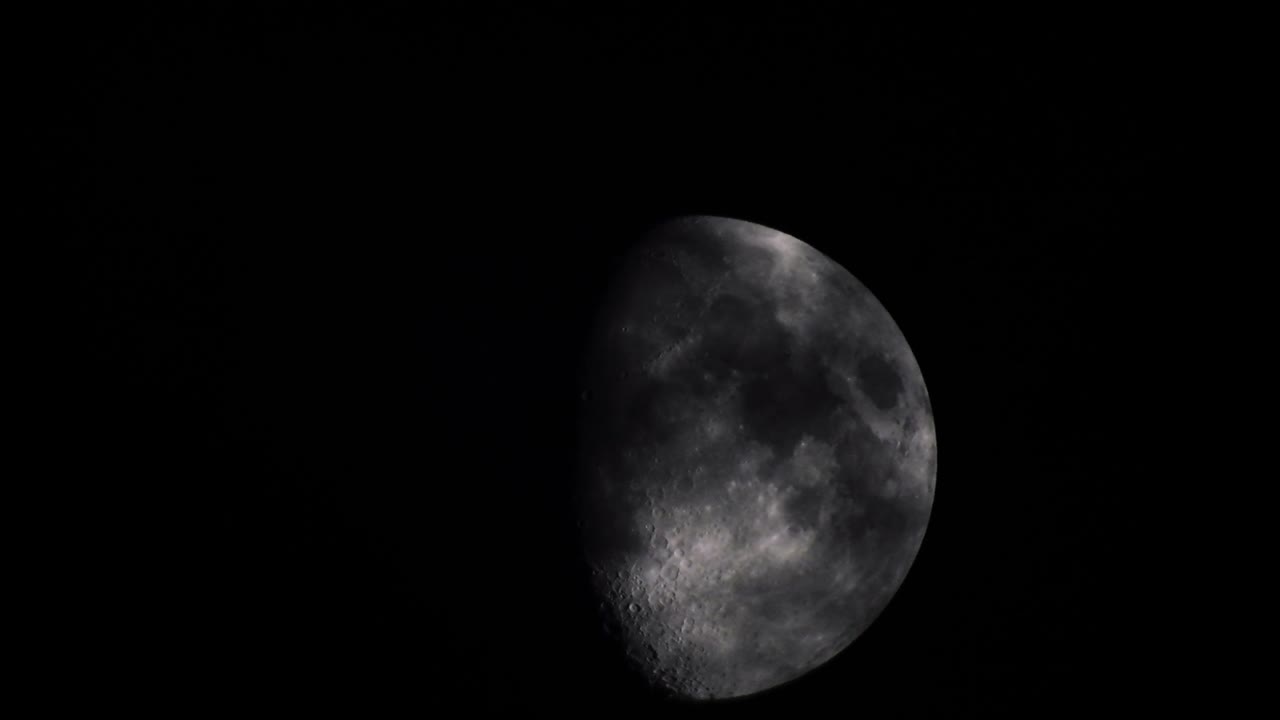 Moon at night with cloud real time. 4k video moon in the black sky.  Clouds passing by moon at night. night sky with cloudy weather