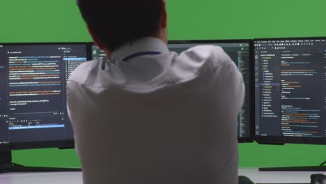 software developer coding on multiple monitors