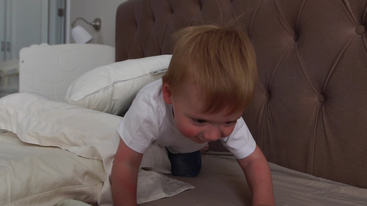 행복한 가족이 집에서 베개로 놀고 침대에서 싸우고 있습니다.