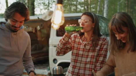 Young-Friends-Preparing-Dinner-and-Chatting-at-Campsite