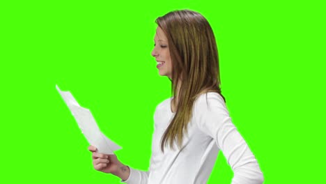 joven mujer rubia marrón leyendo una carta con muy buenas noticias y luego anima a la cámara