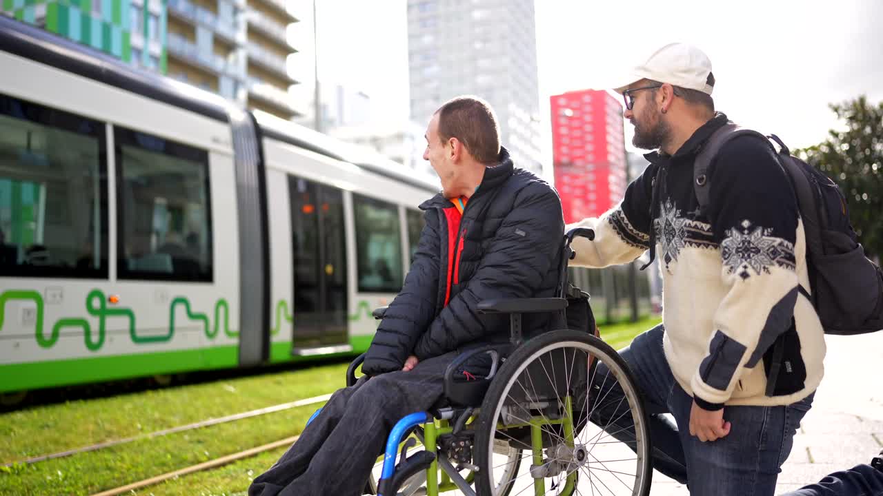 Man in Wheelchair Assisted by Friend Near Tram