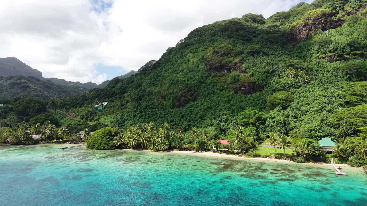 Huahine Island, French Polynesia. Revealing Drone Shot of Green Landscape, Beach and Beachfront Homes