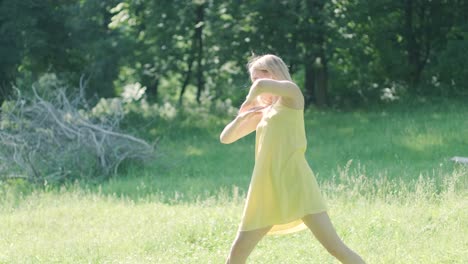 woman in yellow dress dancing gracefully in summer park