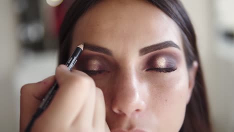 Close-Up-Of-Attractive-Model-Makeup-Artist-Painting-With-Pencil-An-Eye-Brow-Line
