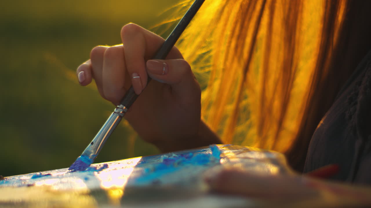 mujer artista pintando al atardecer al aire libre. cerca de las manos de la mujer mezclando pinturas