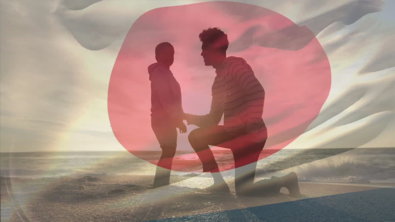 On beach, silhouetted couple with Japanese flag overlay, watching sunset animation