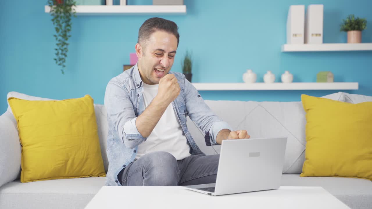 남자는 노트북을 보고 기 ⁇ 합니다.