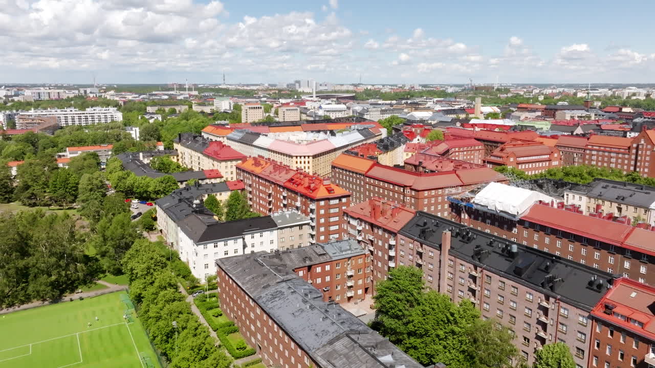 Aerial view over a soccer field and buildings in Toolo, summer day in Finland