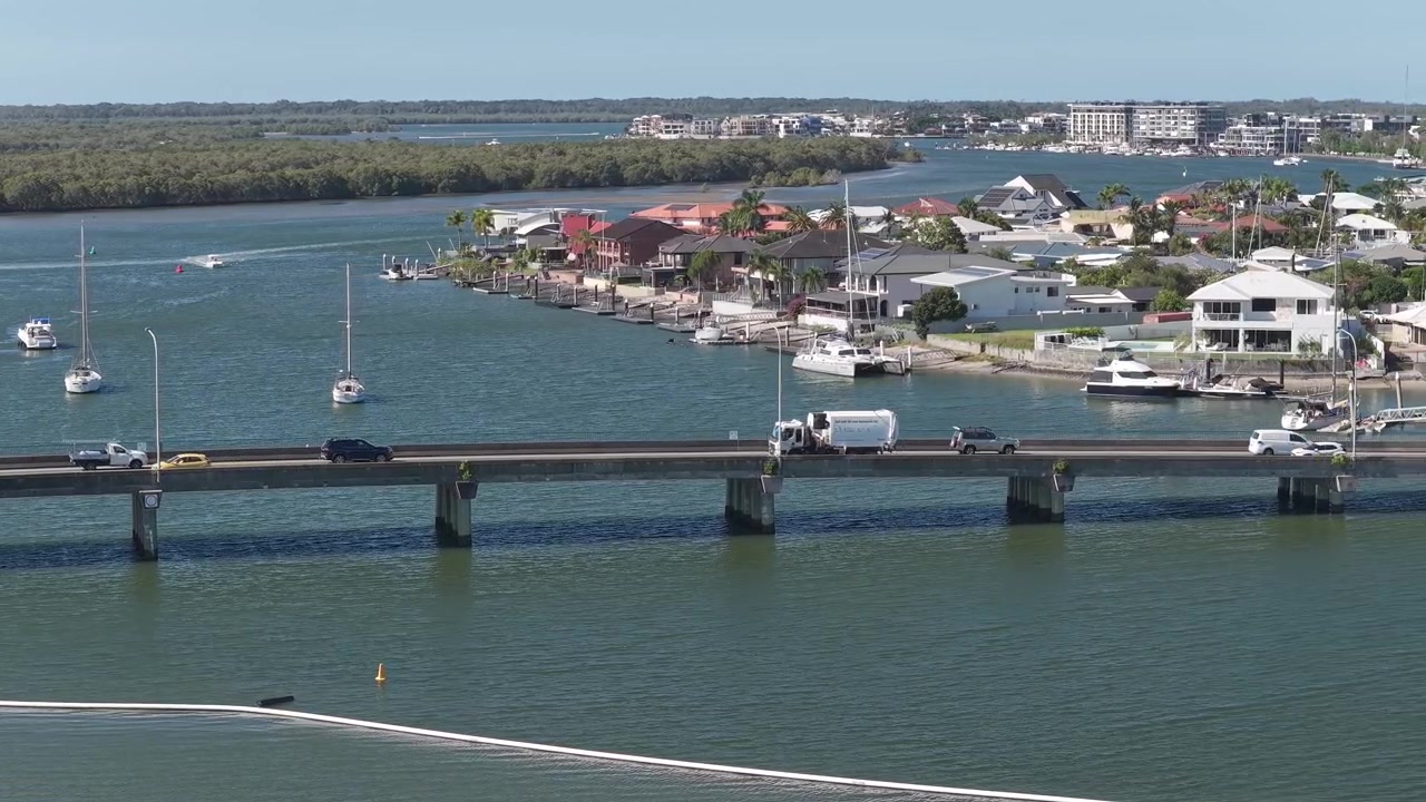 Veicoli che viaggiano lungo il ponte sull'isola di Jabiru, Paradise Point, QLD, Australia - Ripresa da drone